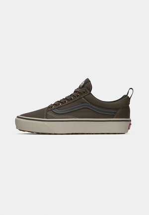 Zapatilla de lona marrón con un perfil bajo, franja lateral en gris contrastante, ojetes metálicos y una suela de goma texturizada. Cuenta con una cinta de agarre.