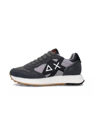 Baskets de sport grises en matériaux en daim et en maille, avec un design géométrique blanc, des accents noirs et une semelle en caoutchouc dotée d'une texture antidérapante.