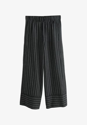 Culotte a righe bianche e nere con una vita elastica, gambe ampie e una texture liscia. Le righe sono verticali, migliorando il design.