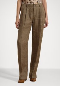 Pantalon en houndstooth marron avec plis, design à jambe droite et ceinture traditionnelle. Le matériau semble texturé et tissé.