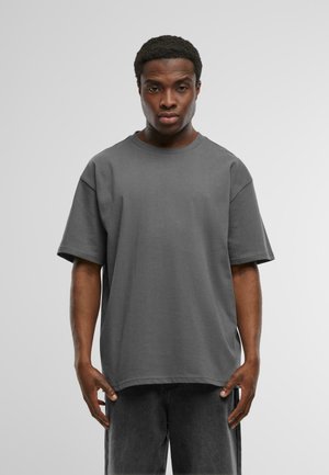 T-shirt grigio in cotone con una vestibilità rilassata, maniche corte e scollatura a girocollo, caratterizzato da una texture liscia e senza motivi visibili.