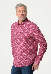 Lange mouw blouse in het roze met een wit bladerenpatroon. De stof is glad met een ontspannen pasvorm. Heeft een klassieke kraag en knopen.