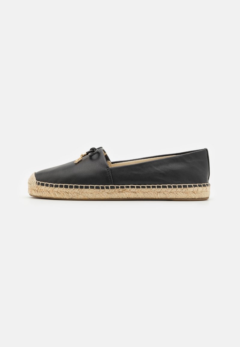 Espadrille plate en cuir noir avec un détail en corde de jute sur la semelle et un petit nœud noir avec des accents dorés à l'avant.