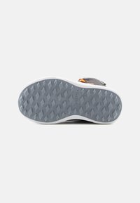Shoe sole with a gray rubber base, featuring a diamond pattern for traction, and a white outer edge. Textured surface and sturdy design.