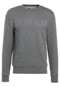 Sudadera gris hecha de una suave mezcla de algodón, con puños y dobladillo acanalados, con "CALVIN KLEIN" impreso en un tono más oscuro en el pecho.