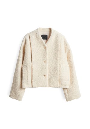 Veste courte couleur crème en tissu texturé, avec un col en V, deux poches latérales et trois gros boutons.