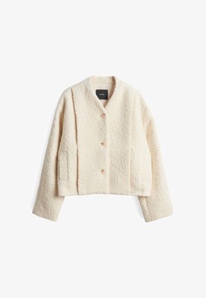 Giacca cropped color crema realizzata in tessuto testurizzato, con scollatura a V, due tasche laterali e tre grandi bottoni.