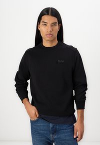 Black sweatshirt made of soft fabric, featuring a crew neck, long sleeves, and a small white "BELSTAFF" logo on the chest.
