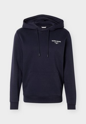 Námořnicky modrá mikina s kapucí, přední kapsou typu klokánek, šňůrkami a bílým logem "BJÖRN BORG STOCKHOLM 1956" na levé straně hrudi.