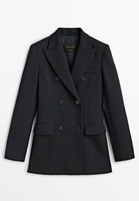 Blazer noir croisé avec revers à pointe, six boutons, deux poches à rabat devant et une poche poitrine passepoilée, posé à plat sur un fond blanc.