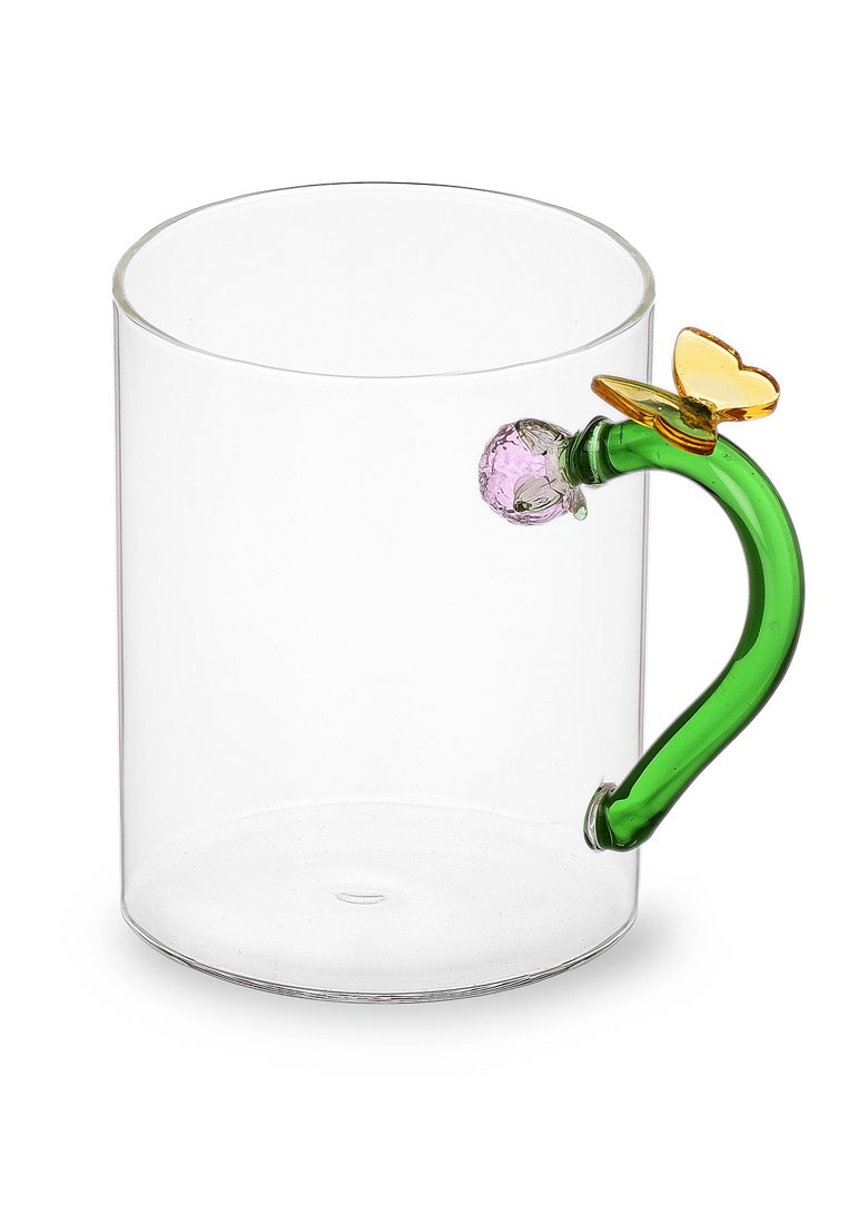 Przezroczysty szklany kubek z zakrzywionym zielonym uchwytem, ozdobiony różowym elementem dekoracyjnym i żółtym akcentem motyla na uchwycie.