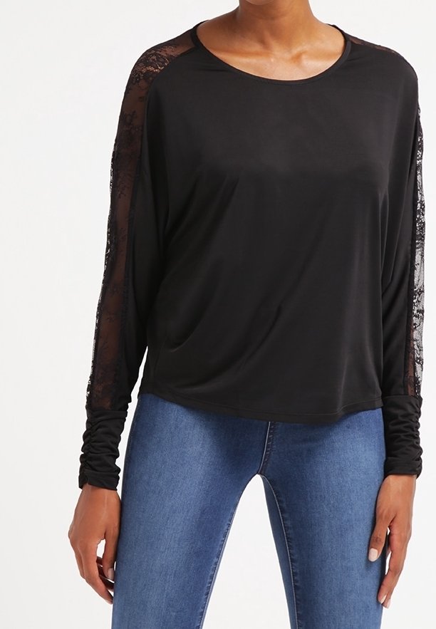 Czarny, długi rękaw bluzka z koronkowymi akcentami na ramionach, okrągłym dekoltem i luźnym kroju. W zestawie z niebieskimi dżinsami. Gładka tekstura.