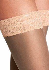 Calze autoreggenti beige con un bordo in pizzo decorativo che presenta un motivo floreale e bordi ondulati; materiale liscia e trasparente al di sotto del pizzo.
