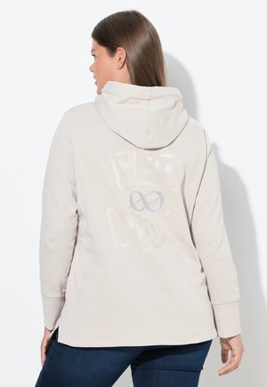 Lichtbeige hoodie met een trekkoord en lange mouwen. De achterkant toont "SEA WAVE" in vet, textuurgegeven letters met een oneindigheidssymbool.