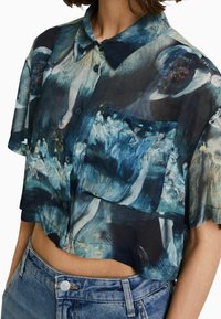 Kortärmad, kort topp i genomskinligt tyg med ett abstrakt blommönster i blått och grönt, med knäppning fram och bröstficka.