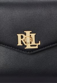 Black leather clutch with a shiny, gold "RL" emblem. Smooth texture, angular design with stitched edging and a secure clasp closure.