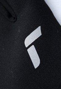 Sort stof med en tekstureret overflade, der har et skinnende sølvlogo i en geometrisk form. Logoet består af vinkelformede segmenter.
