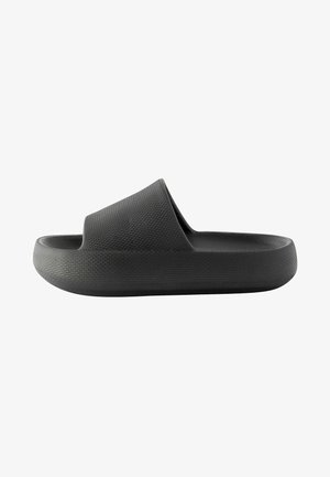 Sandale grise à talon avec un dessus texturé et une semelle lisse. Design ouvert à l'avant, semelle intérieure ergonomique et silhouette minimaliste.