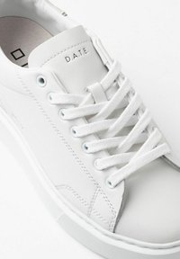 Sneaker bianca in pelle con lacci piatti bianchi, occhielli rinforzati e dettagli grigi sottili. Presenta una linguetta imbottita con il logo "D.A.T.E.".
