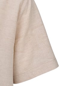 Beige Kurzarmoberteil mit subtiler Textur. Verfügt über eine lockere Passform und sichtbare Nähte am Saum für zusätzliche Details.