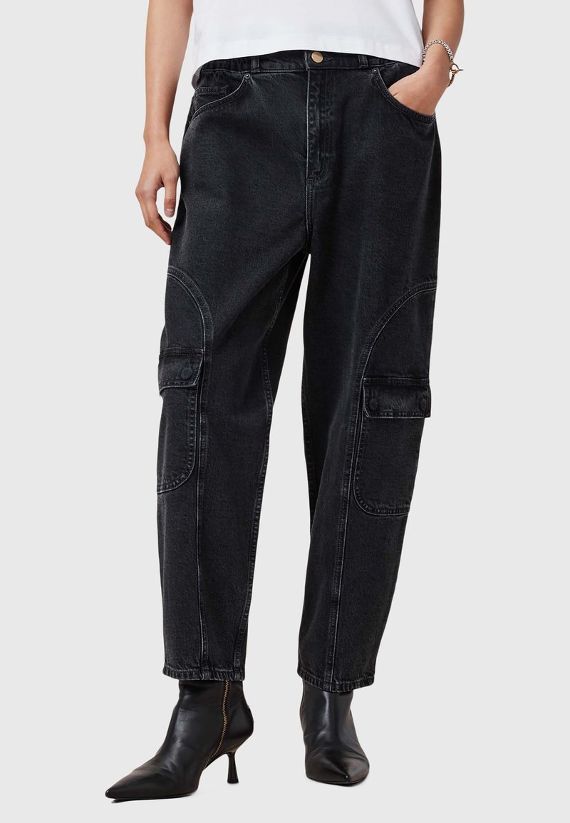 I pantaloni cargo in denim nero presentano una vestibilità comoda, tasche laterali, dettagli con cuciture curve e una chiusura con bottone in vita.