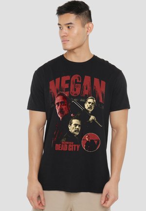 Man wearing black T-shirt featuring red and white graphic of three men and text "Megan The Walking Dead Dead City."