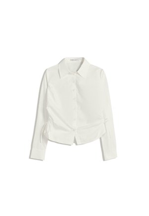Camicia bianca con colletto a pulsante e maniche lunghe, caratterizzata da un taglio corto e dettagli arricciati sui lati. Tessuto morbido con una leggera lucentezza.