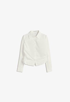 Biała koszula z długim rękawem, zapinana na guziki, o kroju krótkim z marszczonymi detalami po bokach. Gładki materiał z delikatnym połyskiem.