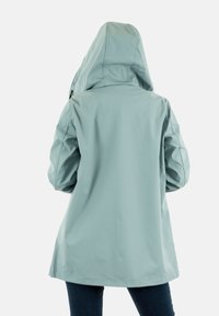 Chaqueta impermeable azul claro con capucha, corte recto y diseño sin costuras, con una textura suave y sin herrajes visibles.