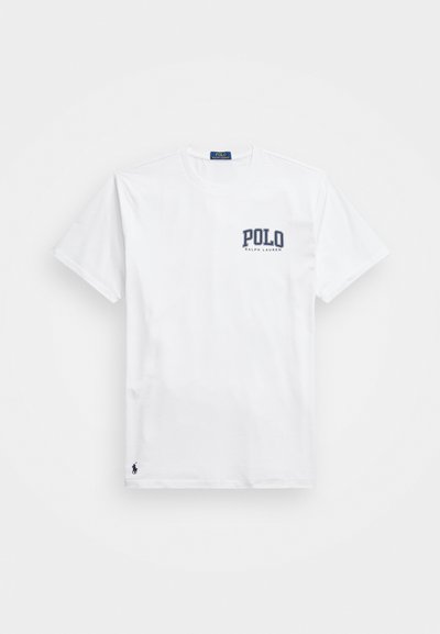 Baltos medvilninės marškinėliai su trumpomis rankovėmis, apvalia iškirpte, „POLO“ logotipas tamsiai mėlynos spalvos ant krūtinės ir mažas tamsiai mėlynas žirgo emblema ties apatine dalimi.