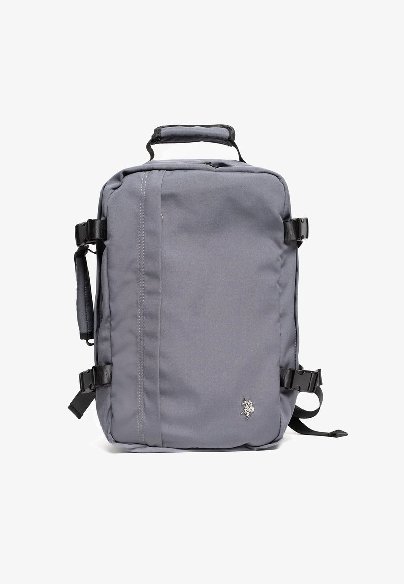 Šedý batoh vyrobený z odolné látky, má obdélníkový tvar, horní rukojeť, nastavitelné popruhy a na přední straně logo.