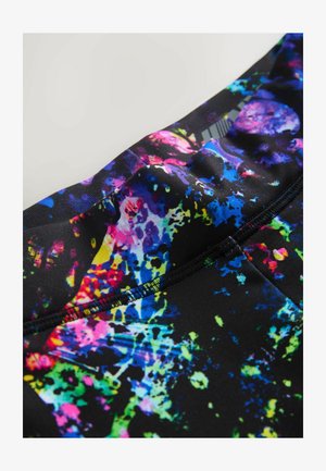 Vzory elastické látky s černým pozadím a jasnými skvrnami růžové, modré, žluté a zelené barvy; hladká textura a přiléhavý design.