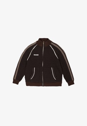 Ruskea neulepusero, jossa korkea kaulus, etuvetoketju, raidalliset beige-harmaat hartiaosan yksityiskohdat ja valkoiset reunukset sivutaskuissa.