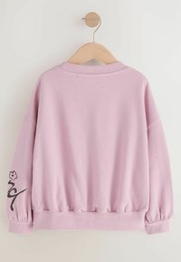 Felpa rosa con scollatura rotonda, maniche lunghe e vita elasticizzata. Presenta una grafica floreale nera su una manica. Tessuto liscio.