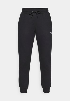 Črne trenirke z vrvico v pasu, ob straneh imajo zapete gležnje in belim logotipom Reebok na levem stegnu. Narejene iz mehkega, trpežnega materiala.