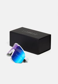 Occhiali da sole con montatura bianca e lenti blu sfumate, presentati accanto a una scatola rettangolare nera con logo in rilievo.