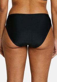 Bas de bikini taille haute noir en tissu extensible. Présente une bordure festonnée le long de la taille et des côtés ajourés.