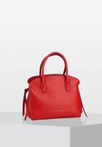 Röd läderhandväska med två handtag på toppen, en strukturerad form, sidoknyten och en guldfärgade logotyp på framsidan. Slät textur, minimalistisk design.