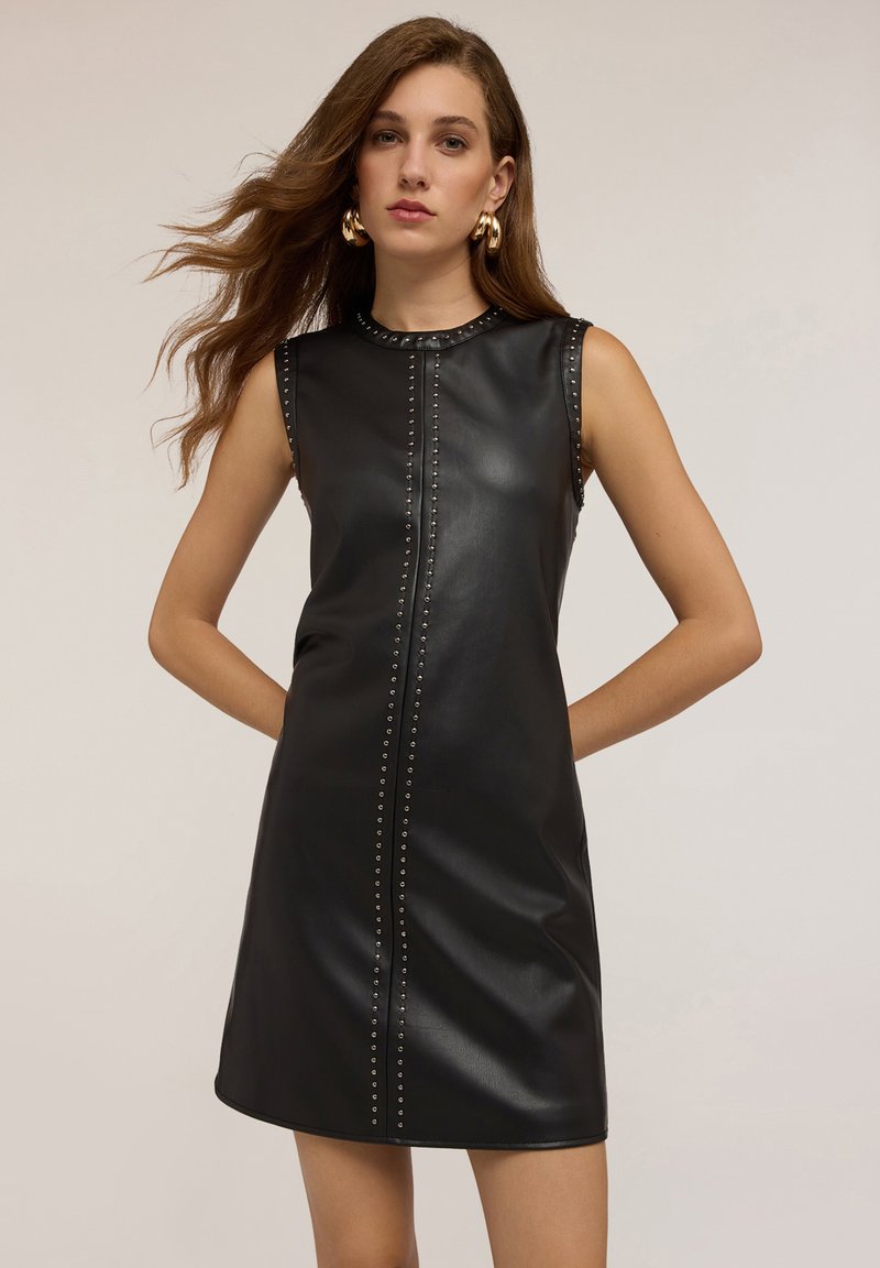 Vestido de cuero negro sin mangas con tachuelas decorativas a lo largo de la costura frontal, con una textura suave y una silueta ajustada.