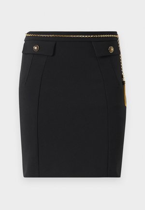 Black fitted skirt with front flap pockets, gold decorative buttons, and a thin gold chain belt with a tassel on the right side.