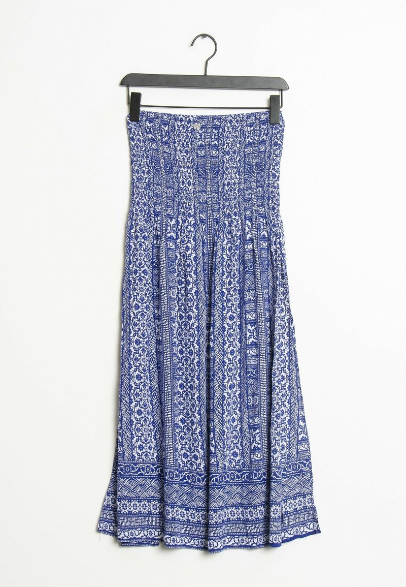 Robe bustier bleu et blanc à motifs avec corsage smocké suspendue sur un cintre noir sur fond blanc.