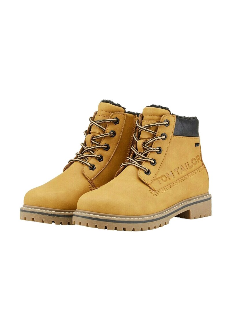 Gelbe Wildleder-Stiefeletten mit schwarzen Akzenten, runder Zehenform, kontrastierenden Schnürsenkeln und einer strukturierten Gummisohle; mit Branding an der Seite.