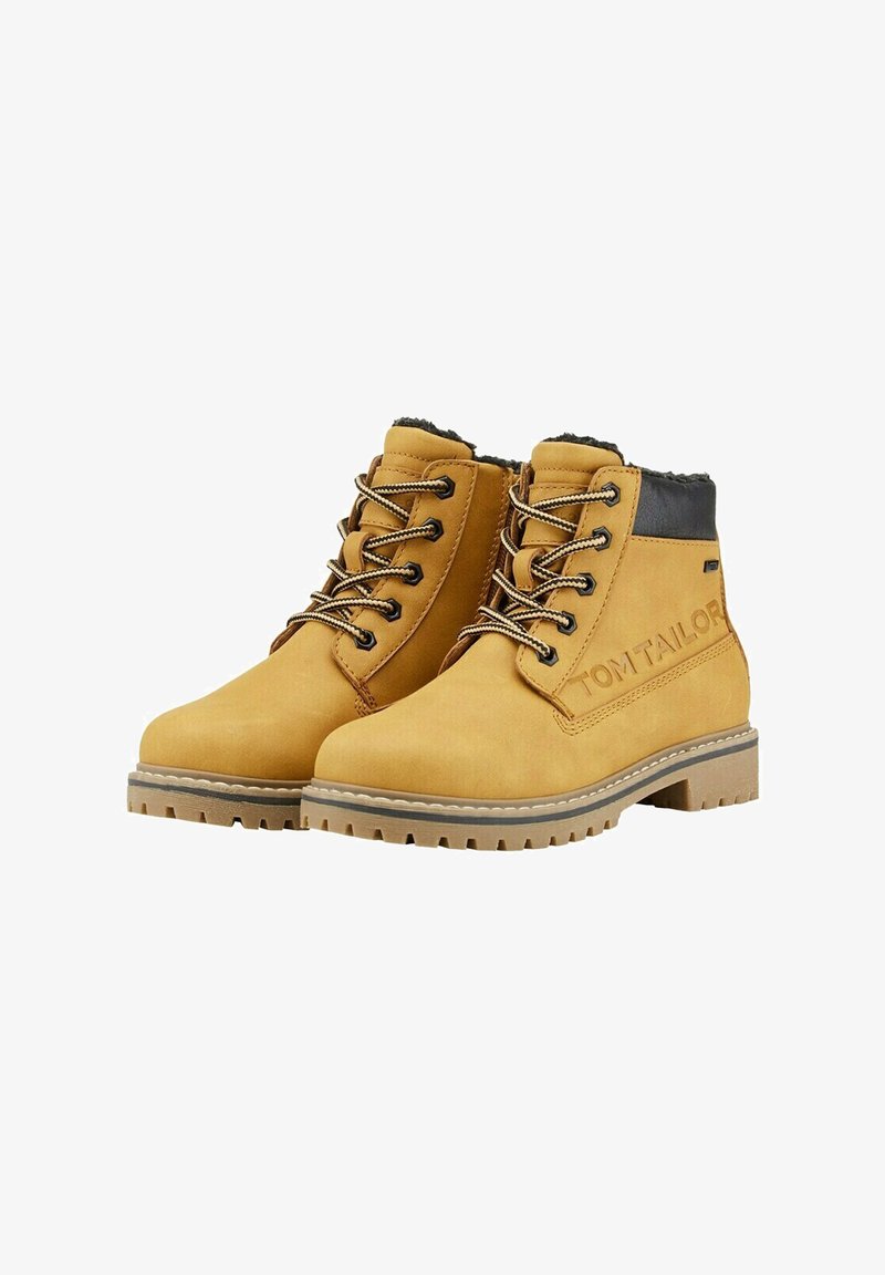 Yellow suede ankle boots with black accents, round toe, contrasting laces, and a textured rubber sole; features branding on the side.