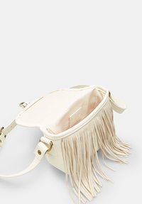 Sac à main en cuir blanc avec des détails en franges, ouvert montrant un intérieur doublé de beige doux, avec des accessoires dorés et une bandoulière.