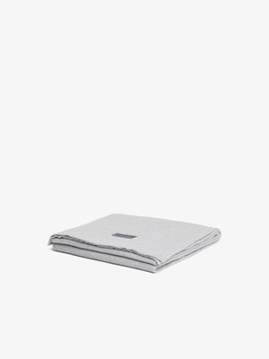 Light gray blanket with a soft texture, featuring a folded design and a small fabric label on one side. Edges are neatly stitched.