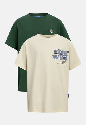 Δύο κοντομάνικα t-shirts με στρογγυλή λαιμόκοψη, το ένα κρεμ με την επιγραφή "stay wild" και γραφικά λουλουδιών, το άλλο σκούρο πράσινο με ένα μικρό μπαλώμα λουλουδιού που χαμογελά.