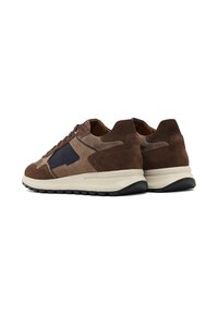 Sneakers in suede e pelle marrone con un accento blu navy, dotati di una suola ammortizzata e una parte superiore testurizzata, progettati per comfort e durata.