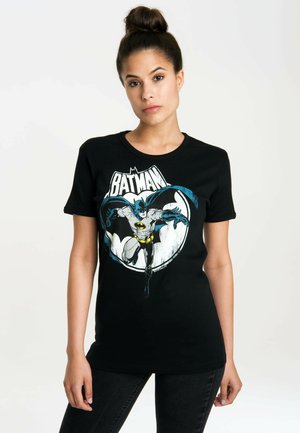 Black cotton t-shirt with a colorful Batman graphic. Features short sleeves and a round neckline. Design includes blue accents and a bold logo.
