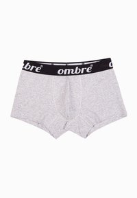 Harmaat puuvillabokserit mustalla vyötärönojalla, jossa on brändin nimi "ombre" valkoisella. Suunniteltu tukevalla etutaskulla.