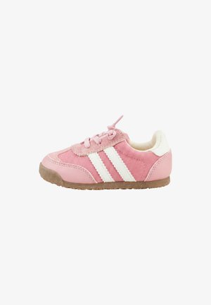 Zapatilla rosa para niño pequeño con rayas blancas, cordones, detalles en ante y suela de goma marrón sobre un fondo blanco.